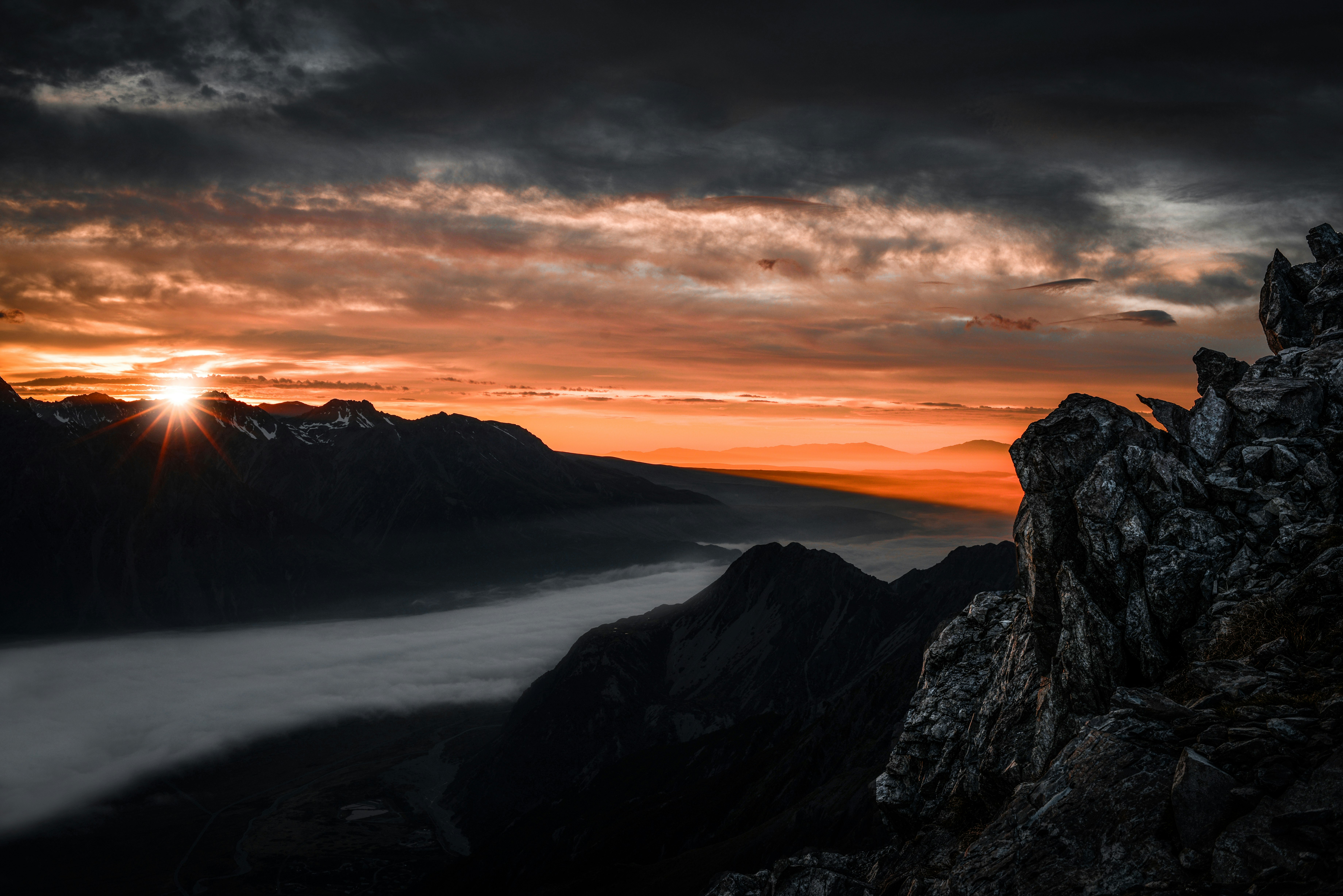 high angle photography of mountain range under nimbus clouds